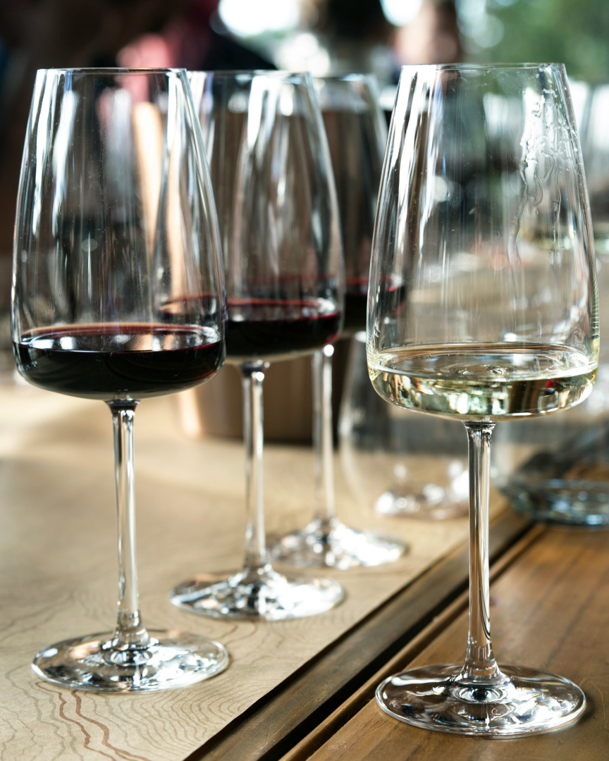 Guests at a wine tasting event sampling different wines in a warm, elegant setting.
